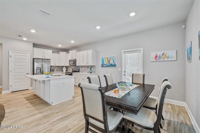 dining space featuring light wood-style flooring, recessed lighting, baseboards, and visible vents