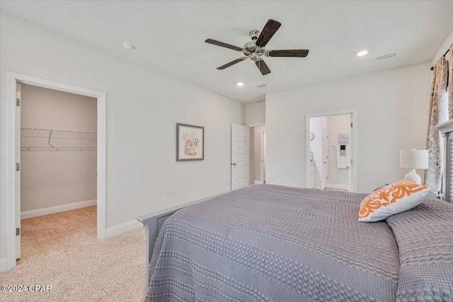 bedroom with recessed lighting, baseboards, light colored carpet, and a spacious closet