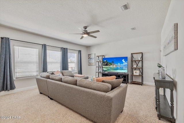 living room with visible vents, light colored carpet, baseboards, and a ceiling fan