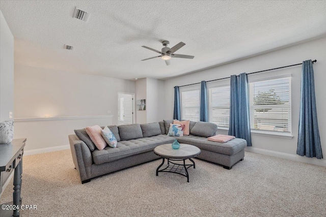 carpeted living area with visible vents, baseboards, a textured ceiling, and a ceiling fan