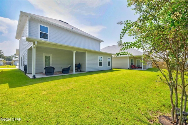 back of property featuring a patio area and a yard