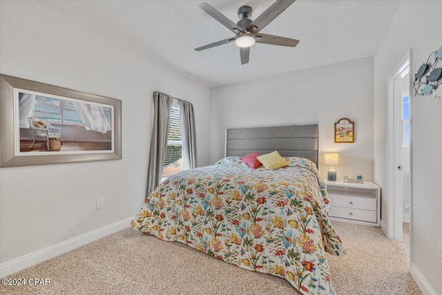 bedroom with a ceiling fan, carpet, baseboards, and a textured ceiling