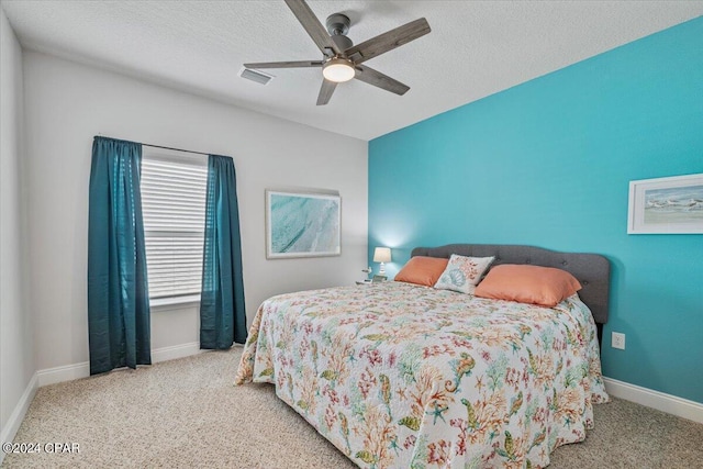 carpeted bedroom featuring visible vents, baseboards, and a textured ceiling