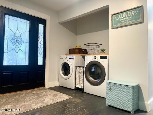 clothes washing area featuring washer and clothes dryer and dark hardwood / wood-style flooring