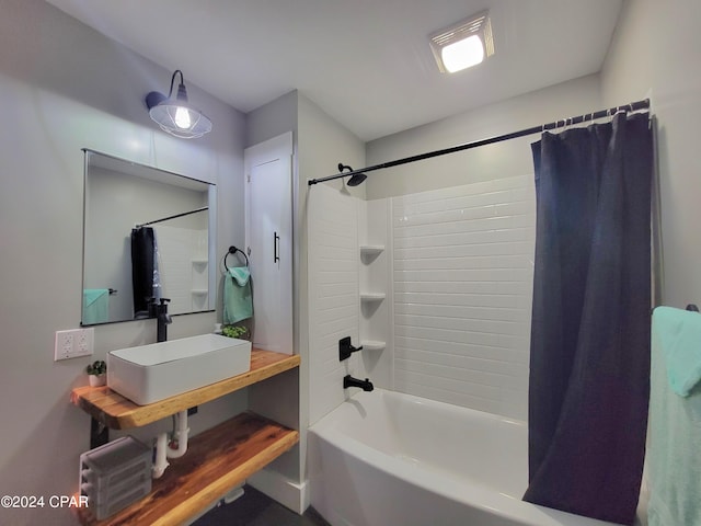 full bath featuring shower / tub combo with curtain and a sink