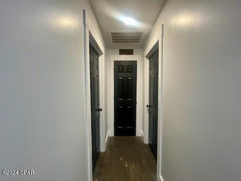 corridor with dark wood-type flooring and visible vents