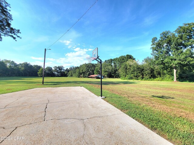 view of basketball court featuring a yard