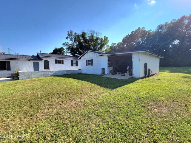 back of house with a lawn and a patio area