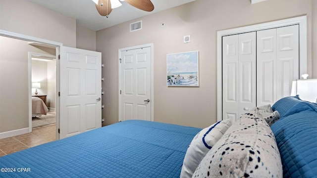 tiled bedroom featuring ceiling fan and a closet