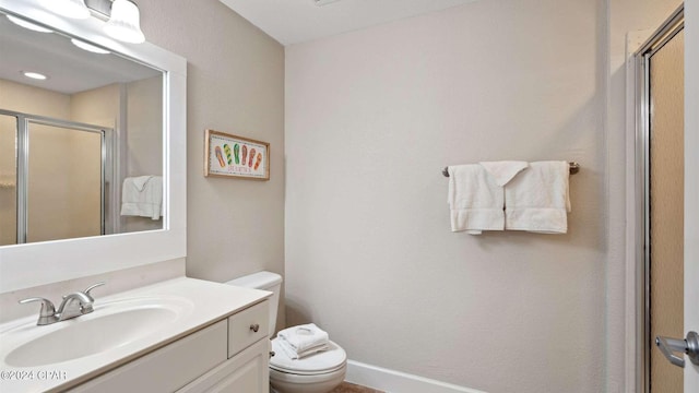 bathroom featuring vanity, an enclosed shower, and toilet