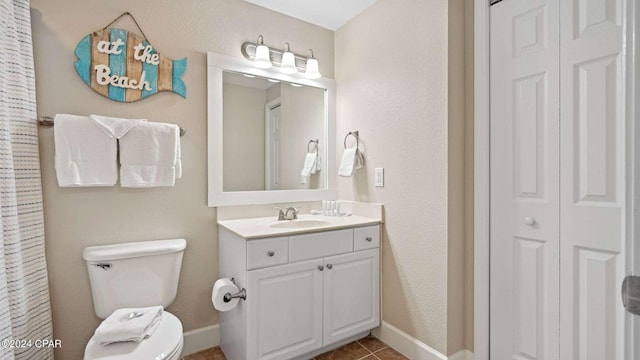 bathroom featuring vanity, toilet, and tile patterned flooring