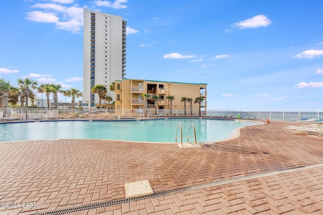 view of swimming pool with a patio and a water view