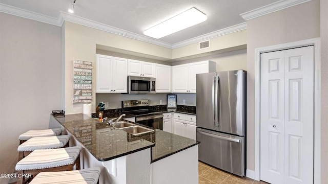 kitchen featuring white cabinetry, sink, a kitchen bar, kitchen peninsula, and stainless steel appliances