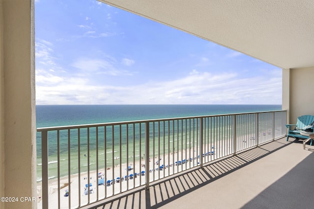 balcony featuring a water view and a view of the beach