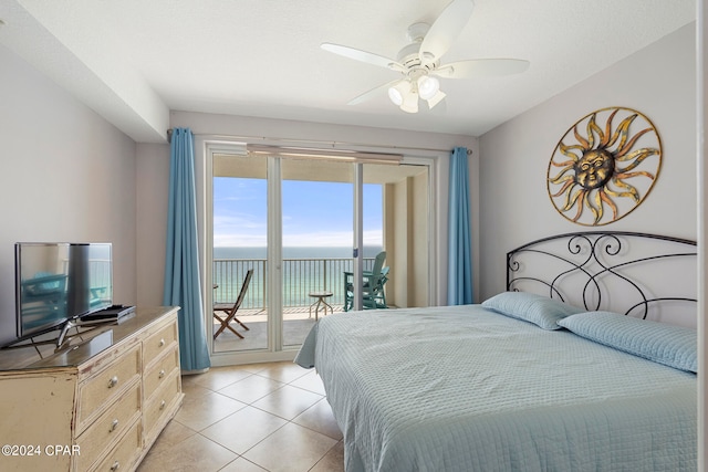 bedroom featuring light tile patterned flooring, a water view, access to exterior, and multiple windows