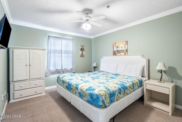 carpeted bedroom with a textured ceiling, ceiling fan, and crown molding