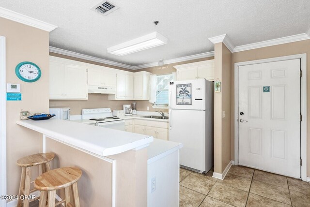 kitchen with white cabinetry, kitchen peninsula, crown molding, light tile patterned flooring, and white appliances