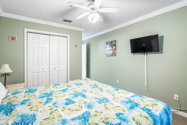 carpeted bedroom with ceiling fan, crown molding, a closet, and a textured ceiling