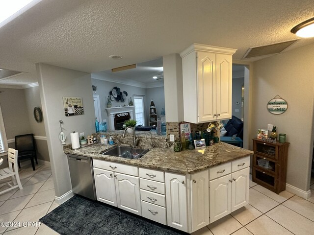 kitchen with light tile patterned floors, dishwasher, sink, tasteful backsplash, and a textured ceiling