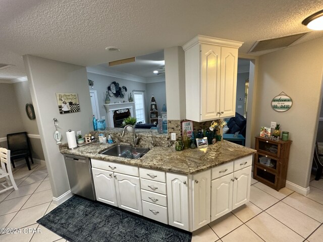 kitchen featuring stainless steel dishwasher, tasteful backsplash, sink, and light tile patterned flooring