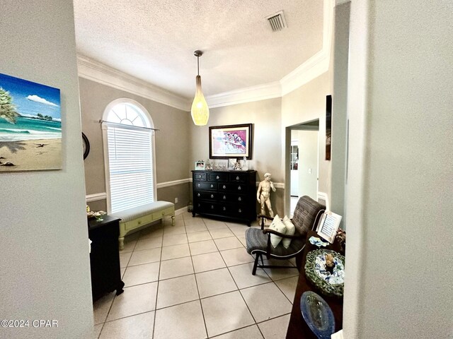 interior space with ornamental molding, light tile patterned flooring, and a textured ceiling