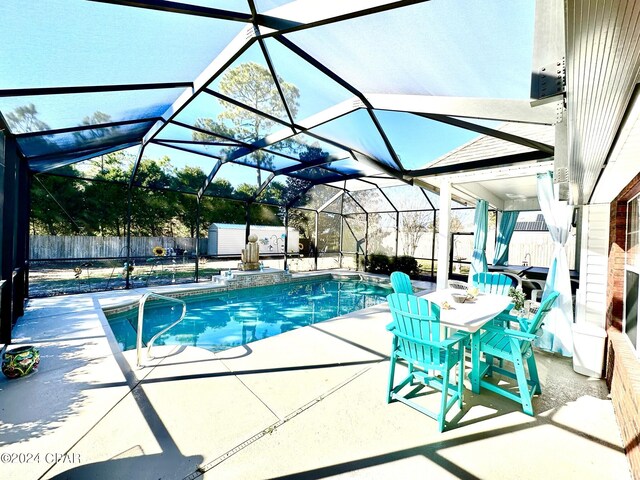 view of swimming pool featuring glass enclosure and a patio area