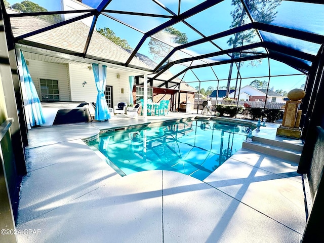 view of pool featuring glass enclosure and a patio