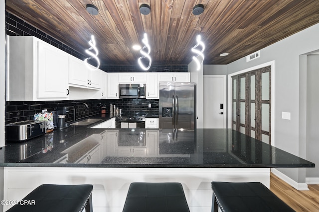 living room featuring wood ceiling, a large fireplace, and light hardwood / wood-style floors