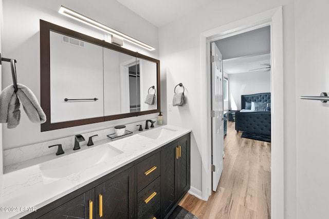 bathroom with toilet, hardwood / wood-style floors, dual vanity, and stacked washing maching and dryer