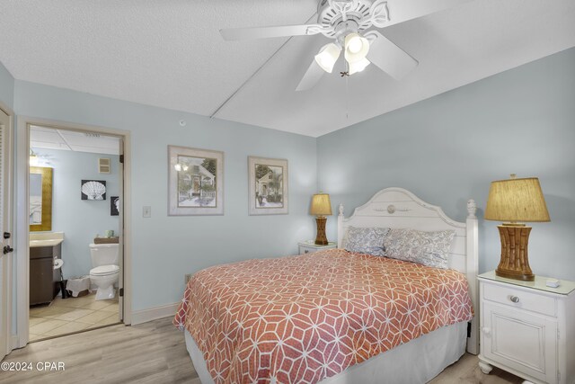 bedroom featuring connected bathroom, ceiling fan, and light wood-type flooring