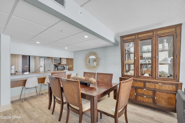 dining space with sink and light hardwood / wood-style floors