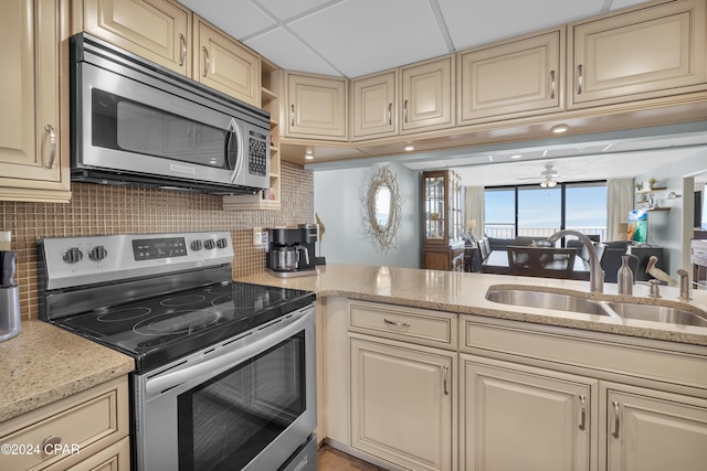 kitchen with tasteful backsplash, stainless steel appliances, a drop ceiling, and sink