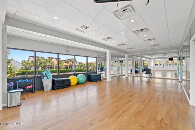 exercise area featuring a paneled ceiling, hardwood / wood-style floors, and french doors