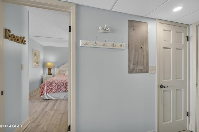 corridor with light wood-type flooring and electric panel