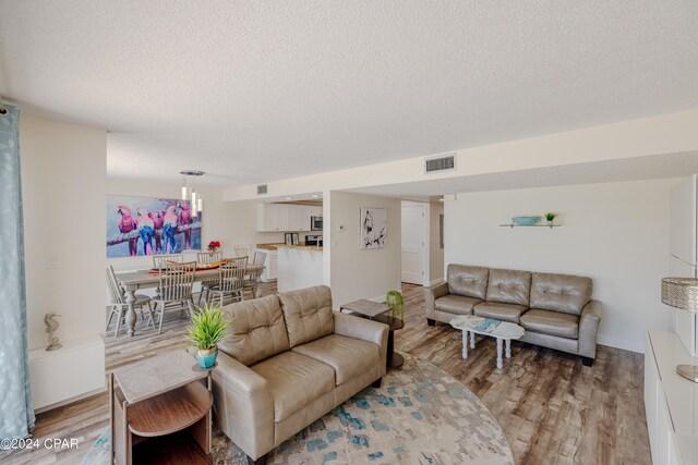 living room featuring a textured ceiling and light hardwood / wood-style flooring