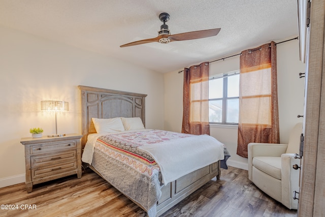 bedroom featuring wood-type flooring, a textured ceiling, and ceiling fan