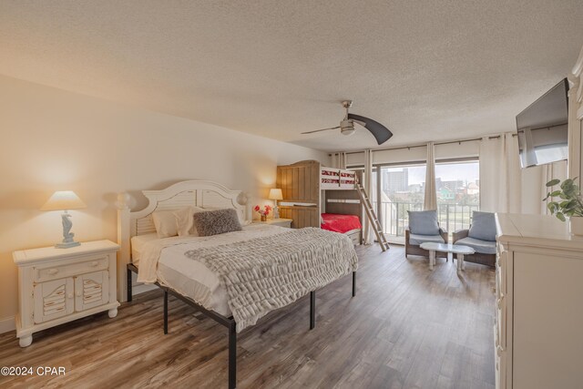 bedroom featuring ceiling fan, hardwood / wood-style floors, and a textured ceiling