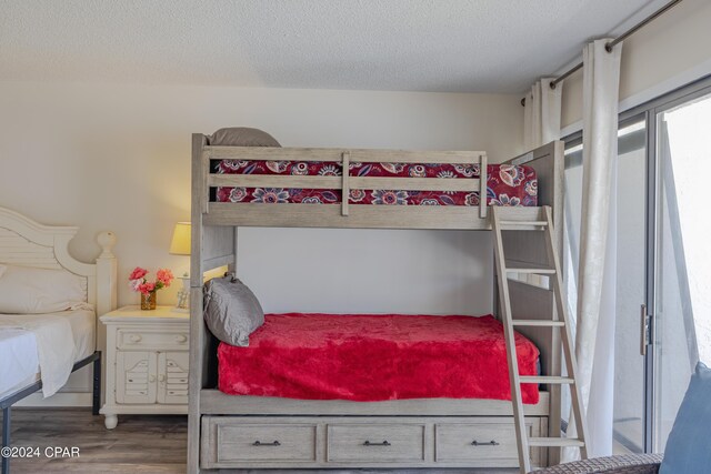 bedroom with a textured ceiling and dark hardwood / wood-style floors