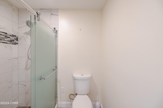 bathroom with toilet and a shower with shower door