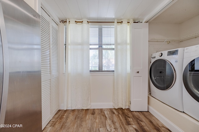 clothes washing area featuring hardwood / wood-style flooring and washing machine and dryer