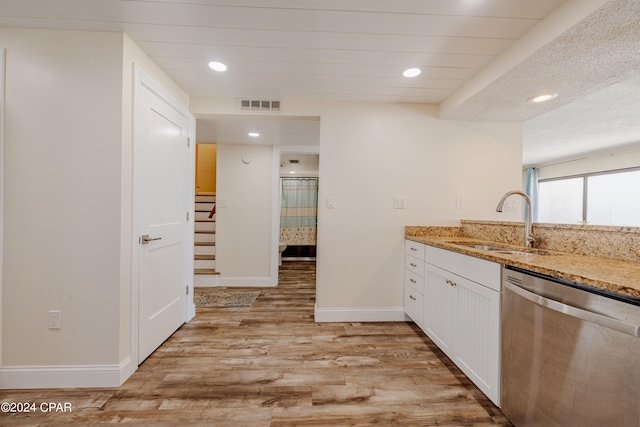 kitchen with white cabinetry, light stone countertops, light hardwood / wood-style flooring, stainless steel dishwasher, and sink