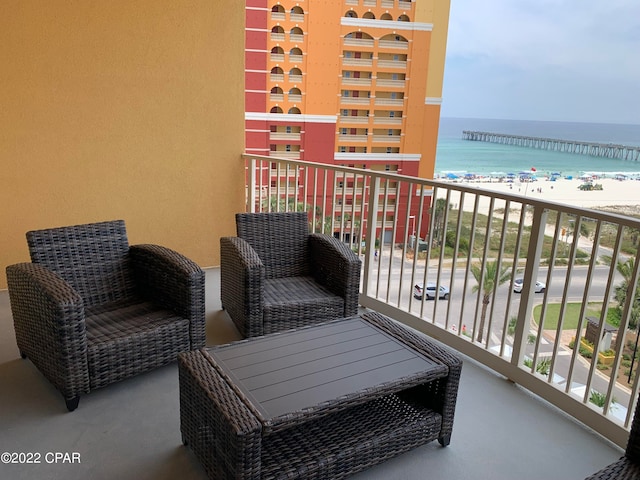 balcony featuring a water view and a view of the beach