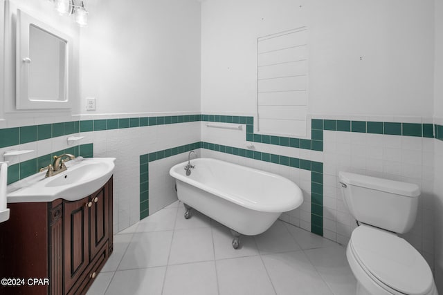 bathroom featuring tile walls, toilet, vanity, a bathing tub, and tile patterned flooring