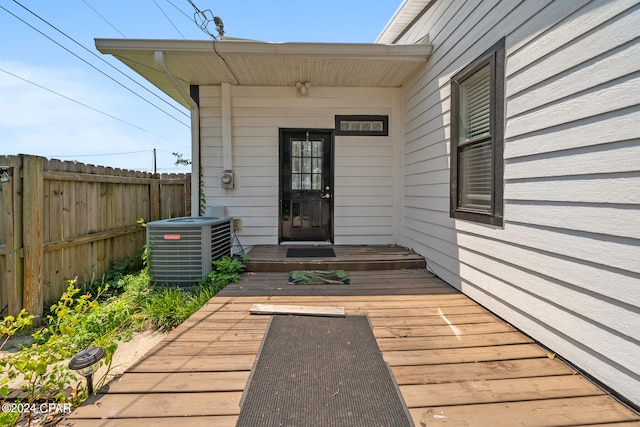 property entrance featuring a wooden deck and central AC unit