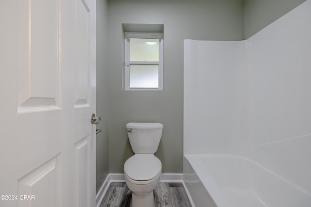 bathroom featuring shower with separate bathtub, hardwood / wood-style flooring, and toilet