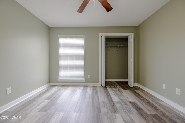 unfurnished bedroom featuring a closet, light hardwood / wood-style floors, and ceiling fan