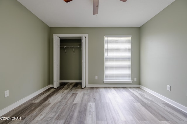 unfurnished bedroom with a closet, light wood-type flooring, and ceiling fan