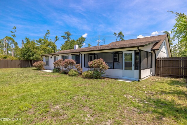 back of property featuring a yard and a sunroom