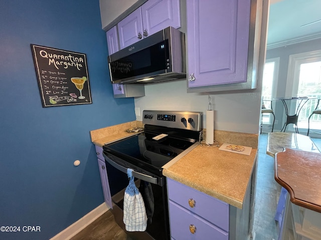 kitchen with ornamental molding, blue cabinets, dark hardwood / wood-style floors, and stainless steel appliances