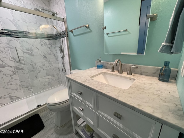 bathroom featuring vanity, a shower stall, and toilet